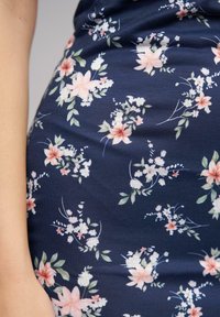 Marine blått stoff prydet med et blomstermønster som har rosa blomster og bladaktige detaljer, med subtil tekstur og myk fall.