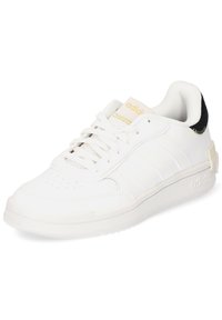 White leather sneaker with a textured surface, three parallel stripes, gold accents, and a black suede heel. Cushioned collar and rubber sole.