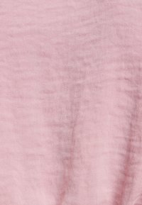 Helle rosa Stoff mit einer weichen, strukturierten Oberfläche. Das Material wirkt leicht und hat einen subtilen Glanz sowie ein leicht zerknittertes Aussehen.