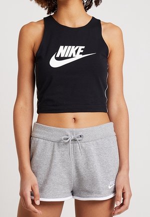 Black cropped tank top with white Nike logo, paired with gray shorts featuring a drawstring and white trim, both made of soft fabric.