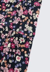 Ein blumengemustertes Gewebe zeigt kleine, bunte Blumen in Rosa, Orange, Lila und Weiß auf einem dunklen, navyblauen Hintergrund mit strukturierter Oberfläche.