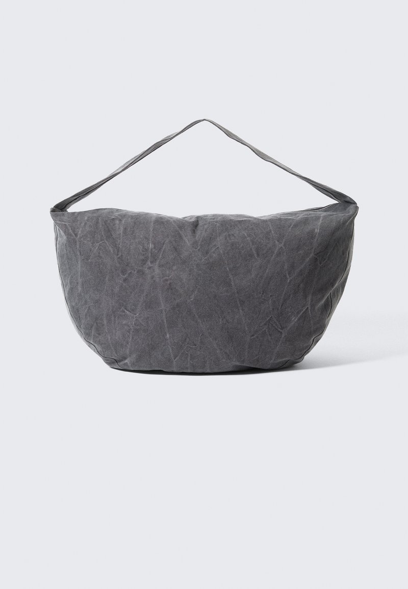 Borsa in tessuto grigio a forma arrotondata con una sola tracolla. Superficie texturizzata con pieghe visibili, design minimalista e senza accessori.