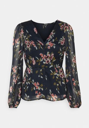 Granatowa bluzka z długim rękawem w różowo-biały kwiatowy wzór, z dekoltem w serek, zapinana na guziki z przodu, z marszczonymi mankietami.