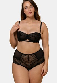 Ensemble de lingerie en dentelle noire comprenant un soutien-gorge et une culotte taille haute, ornés de motifs floraux, avec des bretelles réglables et des détails en mesh transparent.