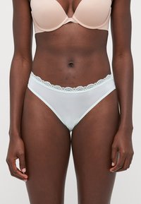 Ljust blå meshunderkläder med spetsdetaljer i midjebandet. Designen har en klassisk bikinitrosmodell, slät textur och inga ytterligare dekorationer.