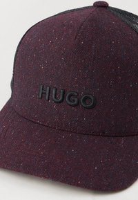 Cappello da baseball testurizzato in bordeaux con retro in rete nera e logo "HUGO" ricamato in nero sul pannello anteriore.