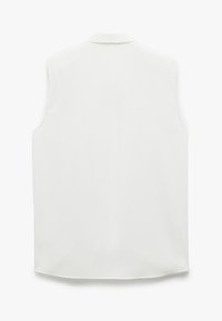 Blouse blanche sans manches avec une texture douce, un éclat subtil et un col classique. Présente une coupe droite et un ourlet légèrement arrondi.