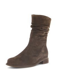 Bottines en suède marron avec une tige souple, un bout rond, un panneau latéral élastique et un petit talon empilé. Texture lisse et design simple.