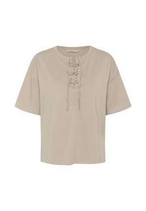 Bež majica kratkih rukava napravljena od mekanog materijala, sa vezivanjem sprijeda uz metalne okice i ležernim krojem.