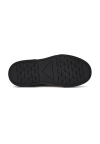 Suola di scarpa in gomma nera con un motivo testurizzato, caratterizzata da forme triangolari e a diamante per una migliore presa. Bordo liscio senza marchi visibili.