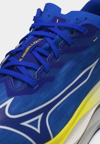 Μπλε αθλητικό παπούτσι με μπλε κορδόνια, λευκό λογότυπο στο πλάι, κίτρινη και λευκή σόλα, και το κείμενο "WAVE REBELLION FL" στη γλώσσα.