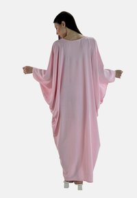 Roze oversized kaftan met brede mouwen, textuurstof en een ontspannen pasvorm, die elegant tot aan de enkels valt.