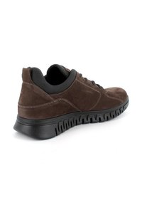 Sneaker low-top in suede marrone con suola in gomma nera testurizzata e cuciture a contrasto. Design con lacci e collo imbottito.