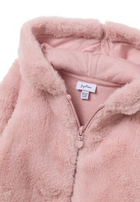 Chaqueta de piel sintética suave de color rosa claro con capucha, cremallera frontal y un tirador de cremallera en forma de corazón. Forro interior de tela suave. Etiqueta de talla visible.