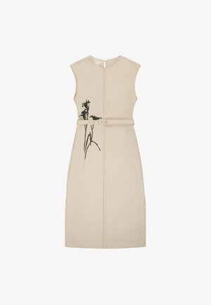 Robe beige sans manches longueur genou avec ceinture et imprimé floral noir sur le côté gauche, fermeture au dos par des boutons.