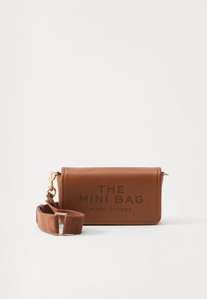 Geantă mini din piele maro, de formă rectangulară, cu accesorii din aur, curea ajustabilă și text embossat "THE MINI BAG MARC JACOBS".