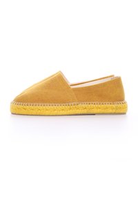 Scarpa slip-on di tessuto giallo con punta affusolata e suola in juta naturale. Presenta cuciture lungo la suola e un design semplice e minimale.