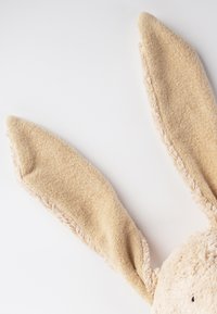 Stuffed rabbit toy with long, fuzzy beige ears and a textured, soft body. Ears feature a slightly darker trim along the edges.