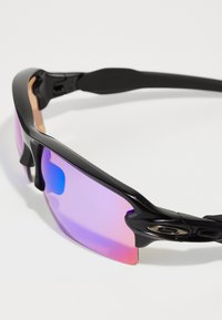 Óculos de sol desportivos pretos com um design envolvente, apresentando lentes espelhadas em gradiente rosa e azul e apoios de orelha em borracha texturizada preta.