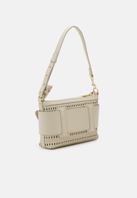 Beżowa torebka z teksturowanym, plecionym wzorem, gładkimi akcentami, regulowanym paskiem i złotymi elementami ozdobnymi. Zamek błyskawiczny na górze.