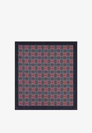 Jedwabny szalik z geometrycznym wzorem w kolorach czerwonym, czarnym i białym, obramowany jednolitym granatowym brzegiem. Gładka faktura i kwadratowy kształt.