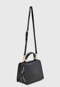 Svart handväska i krokodilskinnsdesign med topphandtag och lång justerbar axelrem, detaljer i guldton, strukturerad rektangulär form.