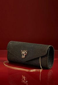 Juodas blizgus rankinukas su auksinės spalvos panteros galvos užsegimu. Turi elegantišką formą, sulankstomą dizainą ir nuimamą auksinės spalvos grandinėlę.