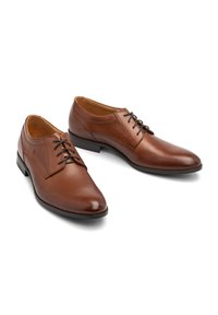 Zapatos de vestir de cuero marrón con un acabado suave, punta afilada y diseño de cordones. Presentan costuras sutiles y una suela negra robusta.