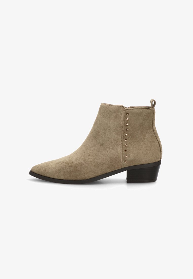 Botines de ante beige con puntera puntiaguda, tacón corto en bloque y acentos decorativos de remaches a lo largo del costado. Textura suave y diseño minimalista.