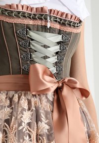 Cuerpo estilo corsé con cintas de satén verdes y rosas, broches plateados, volantes rosas y un lazo de satén rosa atado sobre una falda de encaje floral.