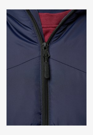 Marineblaue Zip-Jacke aus strukturiertem Stoff, mit mittig angenähtem schwarzen Reißverschluss und Zuglasche, sowie einer bordeauxroten Innenschicht, die am Hals sichtbar ist.