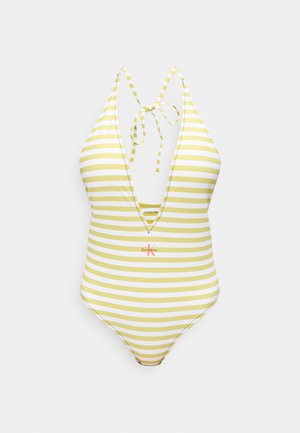 Maillot de bain une pièce à rayures jaunes et blanches avec nouage autour du cou et logo Calvin Klein au centre devant.