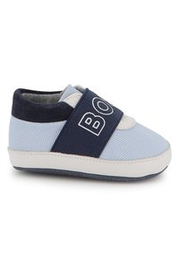 Chaussure en mesh bleu avec des accents en cuir blanc et une sangle marine portant le mot "BOB". Bout arrondi et tissu texturé. Semelle douce.