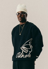 Black sweatshirt with white outline graphic of an ice cream cone and cursive text "Blkvis." Features ribbed cuffs and round neckline.