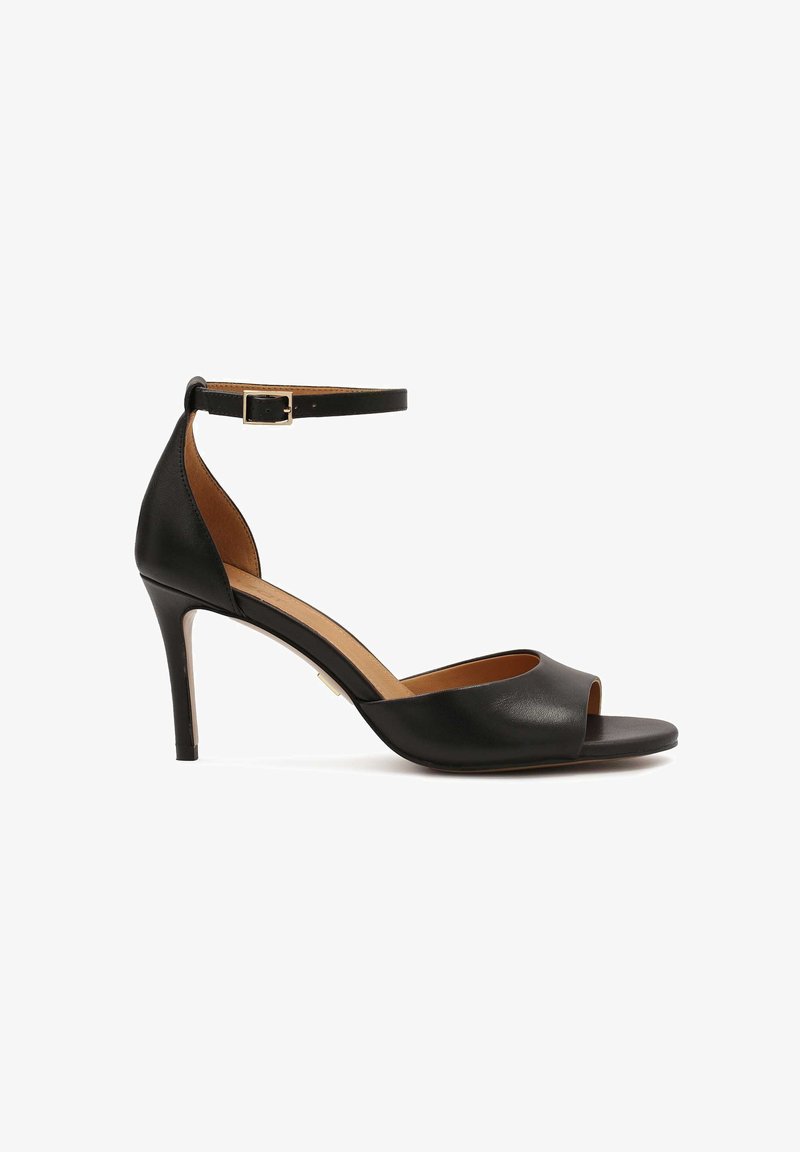 Sandale à talons hauts en cuir noir avec un bout ouvert et une sangle cheville. Présente une texture lisse et un talon fin et effilé.
