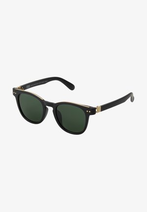 Sunglasses with black matte frame, dark green lenses, gold accents, and two small decorative dots on the front. Slim temple arms.