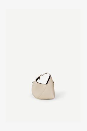 Bolso de cuero beige en forma de media luna con una sola correa para el hombro y costuras mínimas, colocado sobre un fondo blanco liso.