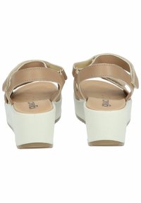 Sandali platform beige con cinturini testurizzati, cinturino posteriore con fibbia e tacco spesso bianco. Suola liscia con logo del brand visibile.