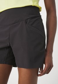 Pantalones cortos deportivos negros con una cinturilla ajustada, que cuentan con un bolsillo lateral y una tela suave y ligera.