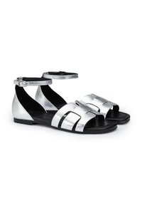 Zilveren leren sandalen met meerdere horizontale banden, open teen en enkelband. Platte zool en een gladde textuur.