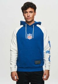 Blue and white hooded sweatshirt with NFL logo, front pocket, and text accents on sleeves. Cotton blend fabric, regular fit.