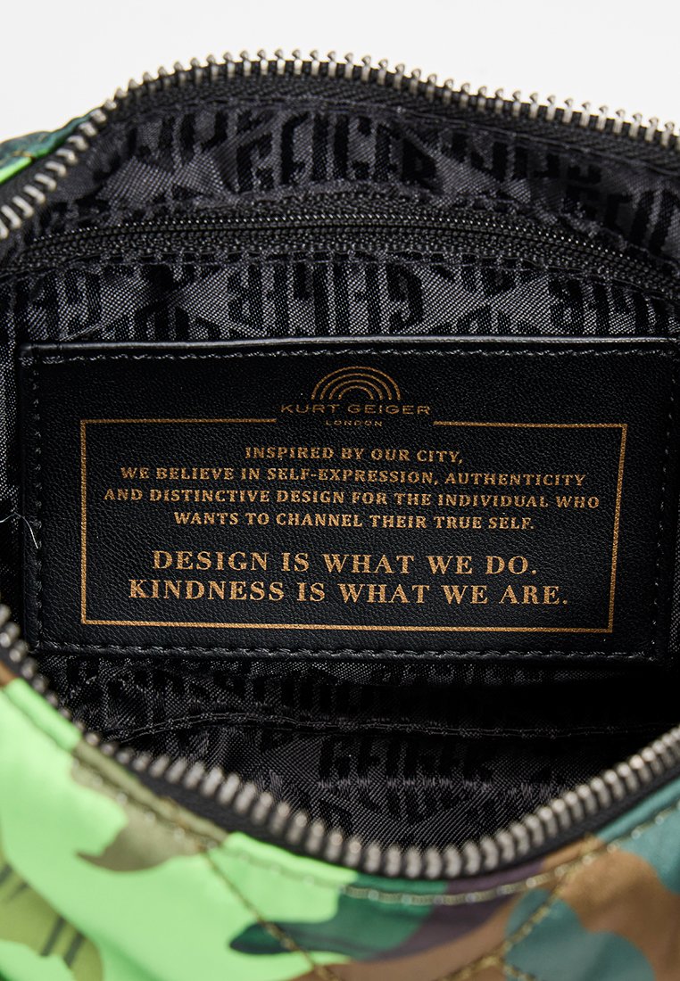 Groene en bruine camouflage tas met een rits. Binnenkant heeft een zwarte voering met een herhalend logo-patroon en een gouden label met tekst.