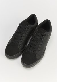 Czarne sneakersy wykonane z skóry i zamszu, z fakturowaną gumową podeszwą. Posiadają płaskie czarne sznurówki i subtelną markę na języku.