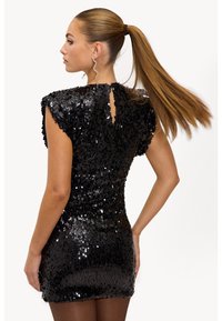 Zwarte paillettenjurk met een aansluitend silhouet, kapmouwen en een sleutelgatdetail aan de achterkant. Gladde textuur en glinsterende pailletten zijn prominent aanwezig.