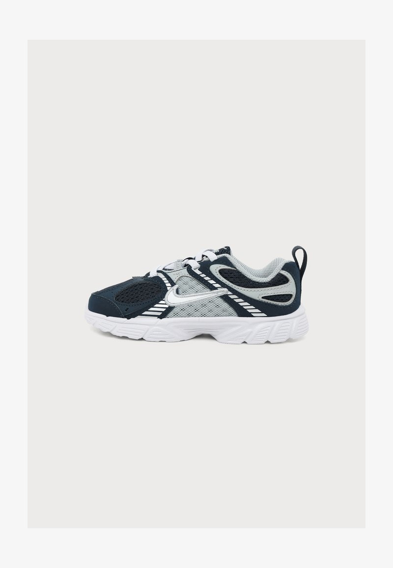 Μαύρο και γκρι αθλητικό παπούτσι Nike με λευκό λογότυπο Swoosh, λευκή σόλα, επάνω μέρος από πλέγμα και ύφασμα, και ταινία έλξης στη φτέρνα.