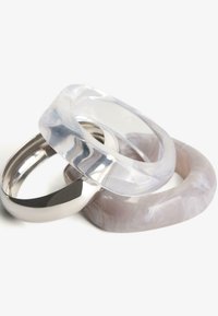 Három karkötő: egy átlátszó akril sima élekkel, egy fényes ezüst fém, és egy örvénylő szürke és fehér márványozott gyanta.