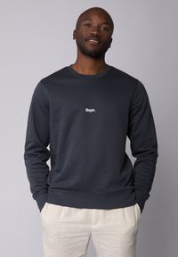 Donkergrijze sweatshirt van zachte stof met een ronde hals en lange mouwen, met de tekst "Nope." in het wit gedrukt op de voorkant.