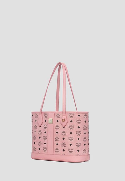 Borsa tote MCM rosa con loghi neri e lunghe tracolle su sfondo neutro.