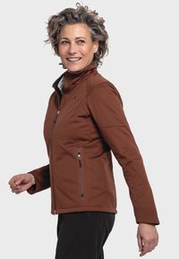 Braune Softshelljacke mit hohem Kragen, Reißverschluss vorne und zwei seitlichen Taschen. Sie zeichnet sich durch ein tailliertes Design und eine glatte Textur aus.