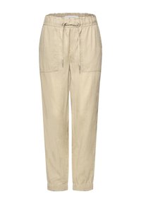 Pantalon beige avec cordon de serrage, taille et poignets élastiques, comportant deux grandes poches plaquées à l'avant et une coupe fuselée décontractée.